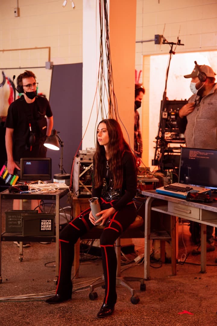 Behind the scenes photo 65 from Clone Cops production showing 2nd ac david king, quinlann ashe, and gaffer barrett dennison between shots on clone cops